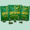 Green gummy bears with 'grüns' packaging on a light green background