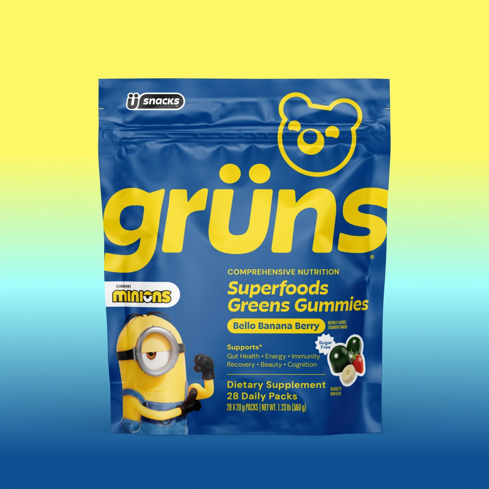 Blue Grüns Superfoods Greens Gummies bag in Bello Banana Berry flavor with Minions branding, on a yellow-to-blue gradient background