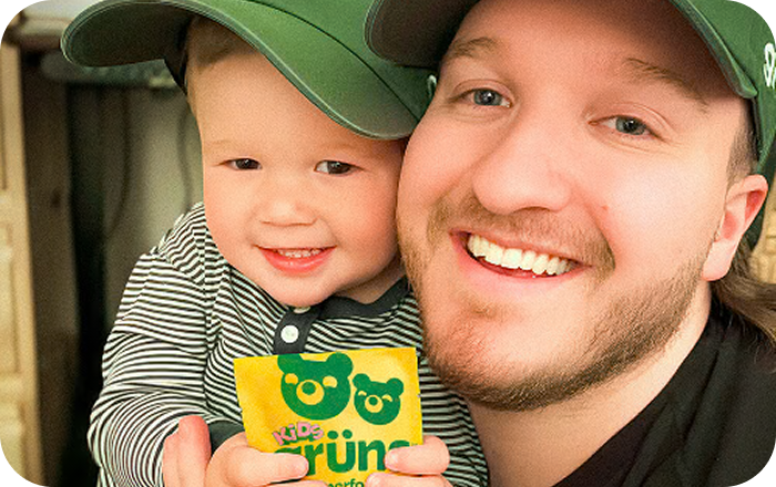 Chad Janis and his son Axel holding a Grüns Kids sachet