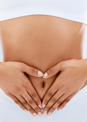 Hands forming a heart shape on a bare stomach.