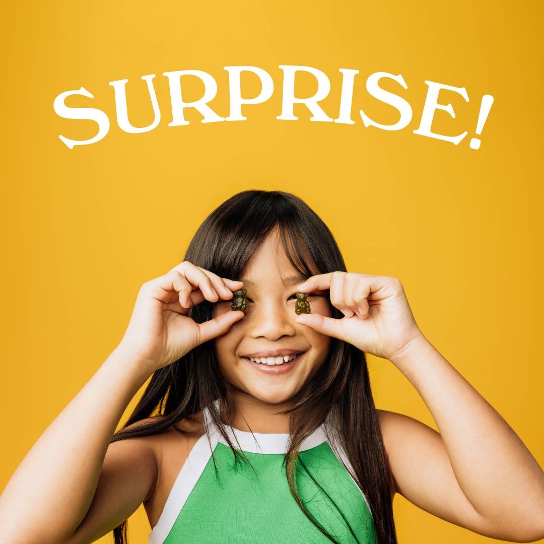 Girl holding gummy bears, smiling with 'Surprise!' text on yellow background.