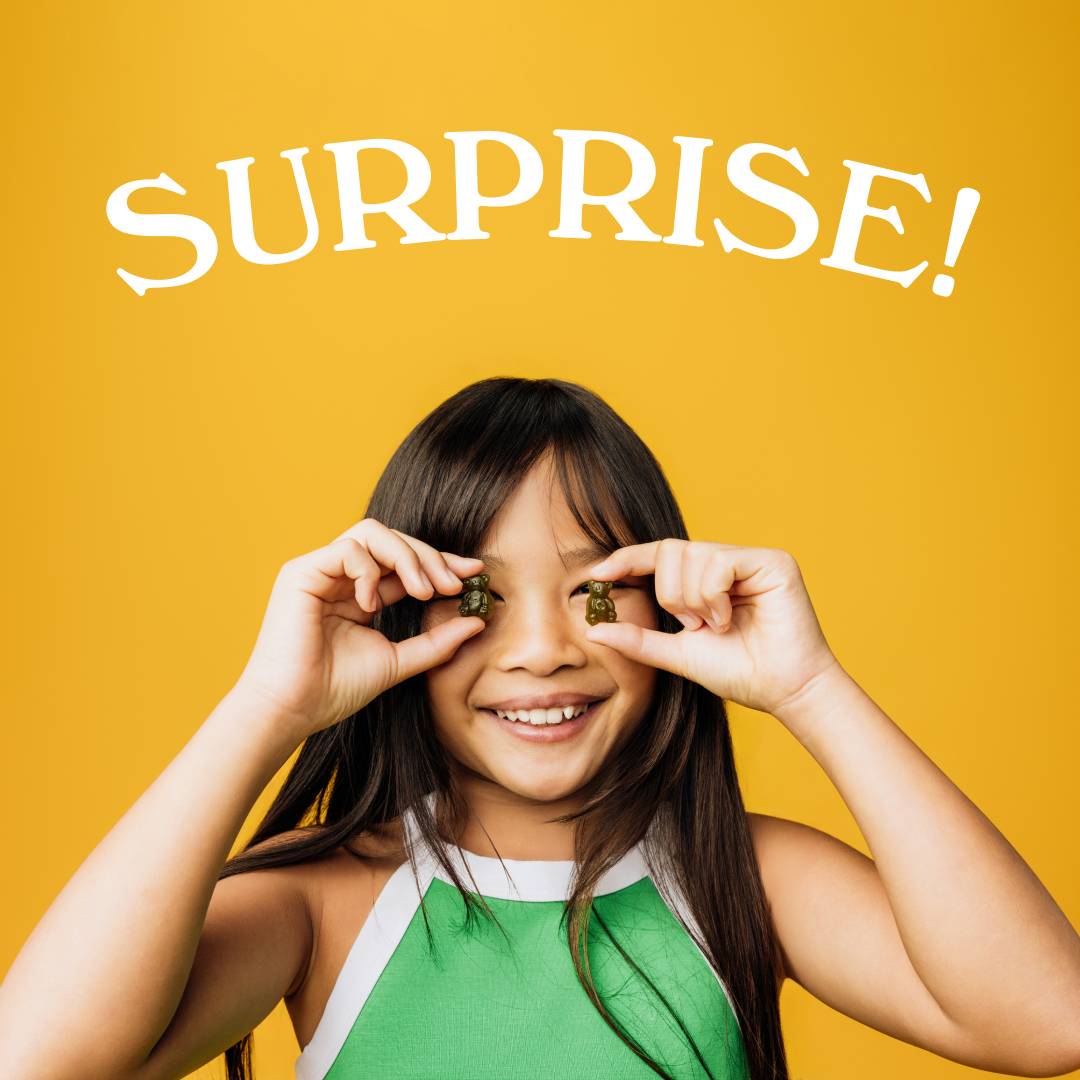 Girl holding gummy bears, smiling with 'Surprise!' text on yellow background.